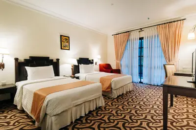 a hotel room with two beds and a desk at Hotel De' La Ferns, Cameron Highlands in Cameron Highlands