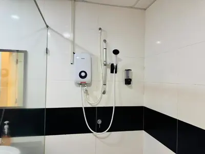 a shower in a bathroom with a shower head at Mansion One by Hejmo Suites in George Town