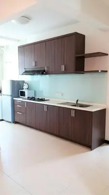 a kitchen with wooden cabinets and a counter top at Partial Seaview with Wifi, Batu Ferringhi in Batu Ferringhi