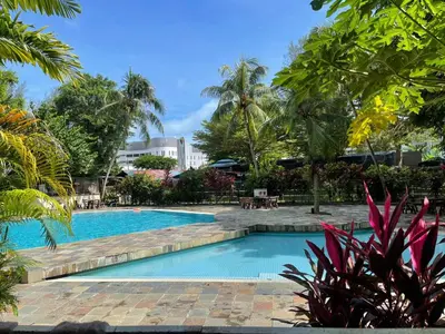 a swimming pool in a resort with palm trees at Partial Seaview with Wifi, Batu Ferringhi in Batu Ferringhi