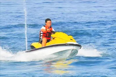 a man riding on a yellow boat in the water at Partial Seaview with Wifi, Batu Ferringhi in Batu Ferringhi