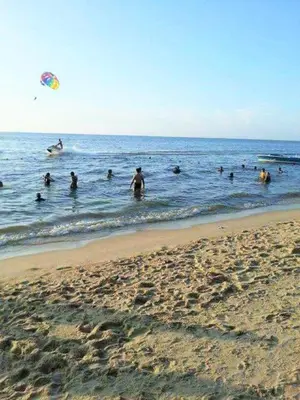 a group of people swimming in the ocean with a kite at Partial Seaview with Wifi, Batu Ferringhi in Batu Ferringhi
