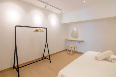a room with a bed and a white wall at Sunrise Gurney in George Town