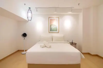 a bedroom with a large white bed with a fan at Sunrise Gurney in George Town