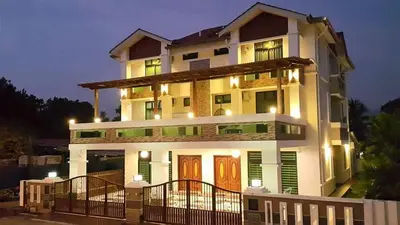 a large white house with a fence in front of it at Woon Homestay in Balik Pulau