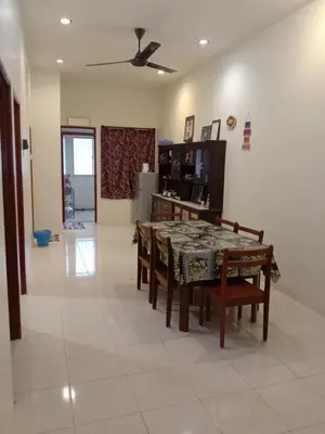 a dining room with a table and chairs and a kitchen at ARUWDA Homestay in Ipoh