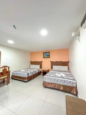 a room with two beds and a table at G Star Hotel in Pantai Remis