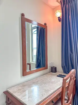 a dressing table with a mirror and a blue curtain at G Star Hotel in Pantai Remis
