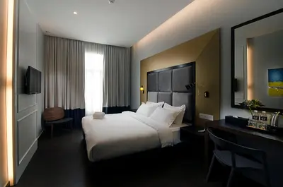 a hotel room with a large bed and a desk at Palm Hotel Ipoh in Ipoh