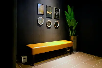 a yellow bench in a room with a black wall at Palm Hotel Ipoh in Ipoh