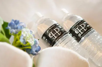 two bottles of water sitting next to some flowers at Palm Hotel Ipoh in Ipoh