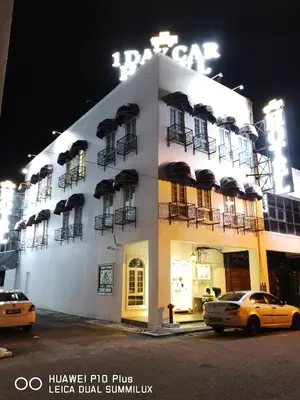 a building with a taxi parked in front of it at 1 Day Car Hotel Station 18 in Ipoh