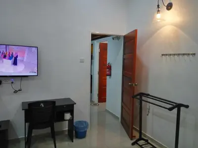 a hallway with a room with a tv and a table at H2O Apartment in Cameron Highlands