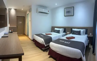 a hotel room with two beds and a table at Pangkor Sandy Beach Resort in Pangkor