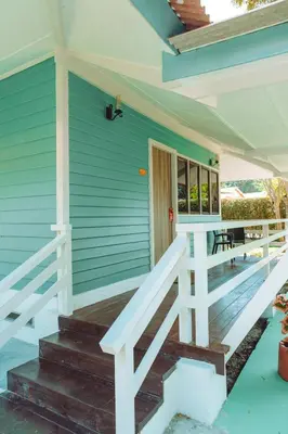 a front porch of a blue house with a white railing at Pangkor Sandy Beach Resort in Pangkor