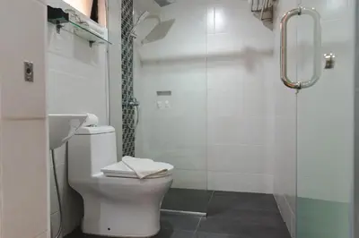 a white bathroom with a toilet and a shower at Pangkor Sandy Beach Resort in Pangkor