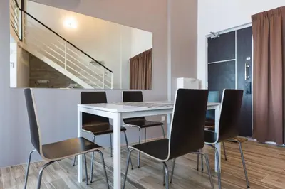 a dining room with a white table and black chairs at 3-Bed Executive Suite, RumahKu @CEO in Bayan Lepas