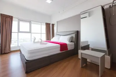 a bedroom with a large bed with a red blanket at 3-Bed Executive Suite, RumahKu @CEO in Bayan Lepas