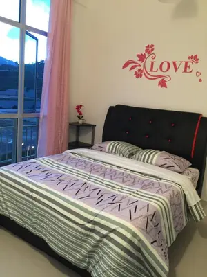 a bedroom with a bed with a love sign on the wall at Cameron DreamWorld Apartment @ Golden Hill in Cameron Highlands