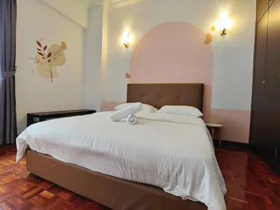 a bedroom with a large bed with white sheets at GurneyVille in George Town
