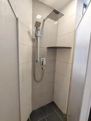 a shower with a glass door in a bathroom at GurneyVille in George Town