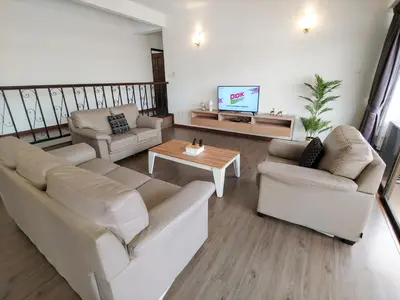 a living room with two couches and a tv at GurneyVille in George Town
