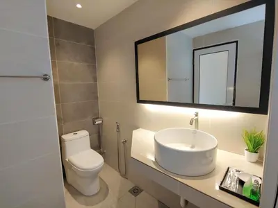 a bathroom with a sink and a toilet and a mirror at GurneyVille in George Town