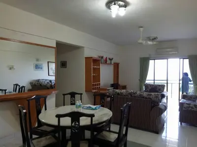 a kitchen and living room with a table and chairs at Lumut Valley Resort Condominium in Lumut