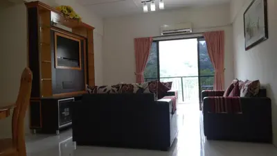 a living room with two couches and a television at Lumut Valley Resort Condominium in Lumut