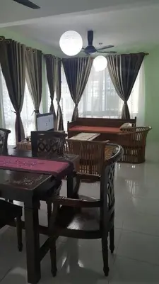 a dining room with a table and chairs and windows at VVIP Homestay Villa Proton City in Tanjung Malim