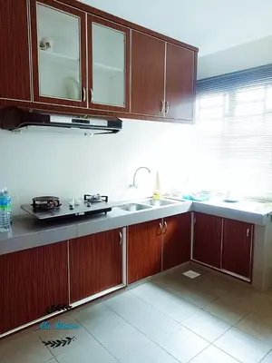 a kitchen with wooden cabinets and a sink at Sri Manjung Ma Maison Homestay in Lumut