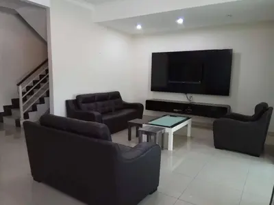 a living room with couches and a flat screen tv at Sri Manjung Ma Maison Homestay in Lumut