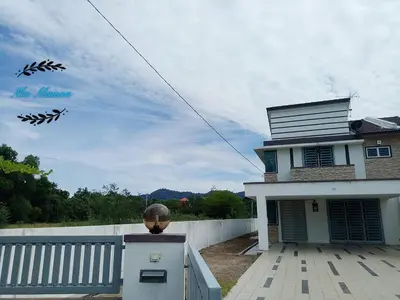 a house with a fence and a kite in the sky at Sri Manjung Ma Maison Homestay in Lumut