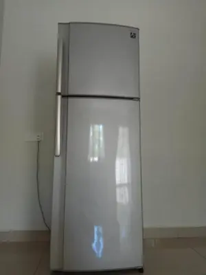 a silver refrigerator in a room with a wall at Sri Manjung Ma Maison Homestay in Lumut