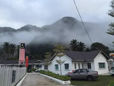 a house with a flag in front of a mountain at Baling Mountain Garden Village in Baling