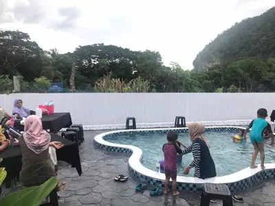a group of people standing around a swimming pool at Baling Mountain Garden Village in Baling