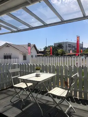 a table and chairs on a patio with a fence at Baling Mountain Garden Village in Baling