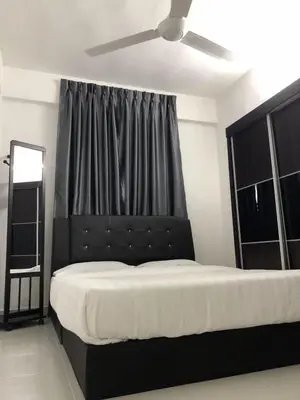 a bedroom with a large bed with a black headboard at Muslim Homestay Apartment in George Town