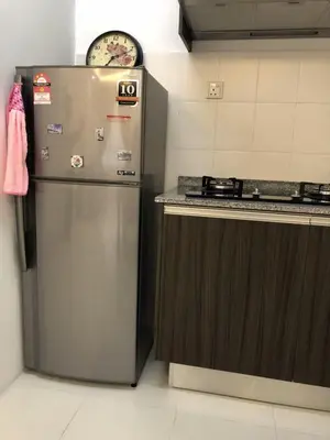 a kitchen with a stainless steel refrigerator and a stove at Muslim Homestay Apartment in George Town