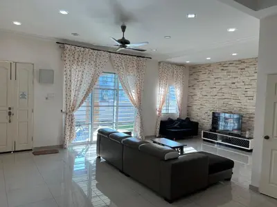 a living room with a black leather couch and a tv at Sitiawan Homestay Entire Semi D house in Sitiawan