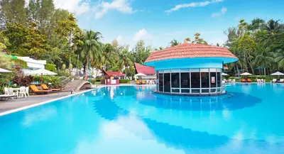 a swimming pool with a building in the middle of it at The Bayview Beach Resort in Batu Ferringhi