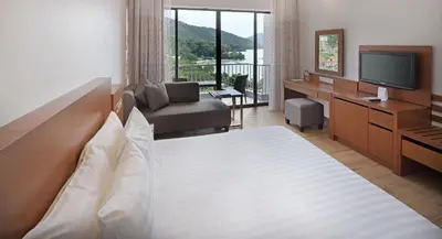 a hotel room with a large bed and a television at The Bayview Beach Resort in Batu Ferringhi