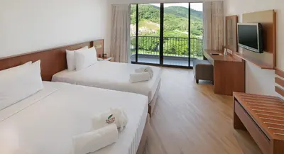 a hotel room with two beds and a television at The Bayview Beach Resort in Batu Ferringhi
