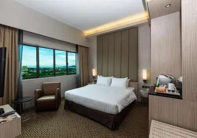 a hotel room with a bed and a chair at Sunway Hotel Seberang Jaya in Perai