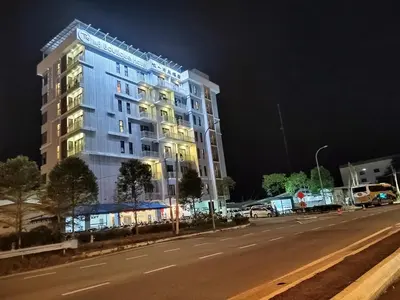 a tall building on the side of a street at night at The One Boutique Hotel in Sekincan