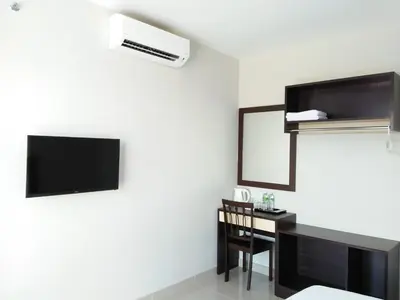a hotel room with a tv and a desk at The One Boutique Hotel in Sekincan
