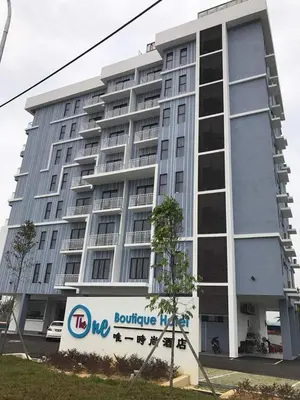 a large building with a sign in front of it at The One Boutique Hotel in Sekincan