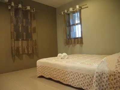 a bedroom with a bed with two white shoes on it at Nature Fruit Farm - Private Estate in Balik Pulau