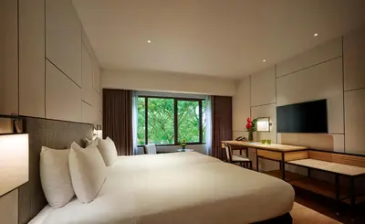 a hotel room with a large bed and a desk at PARKROYAL Penang Resort in Batu Ferringhi