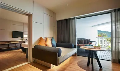 a living room with a couch and a table at PARKROYAL Penang Resort in Batu Ferringhi